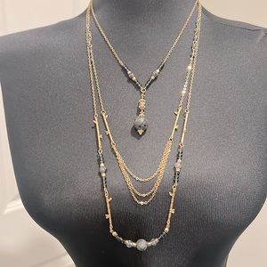 Multi length gold colored layered necklace with blue stones